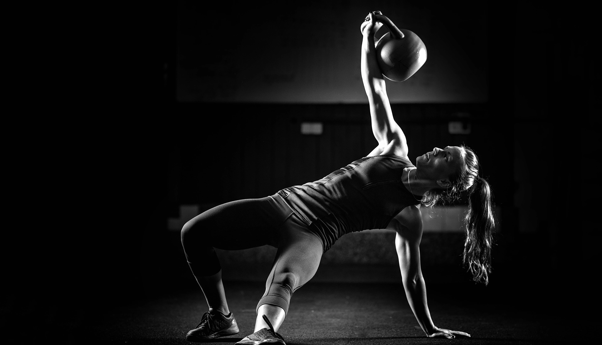 Chica entrenando con pesa rusa.
