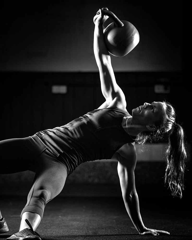 Chica entrenando con pesa rusa.