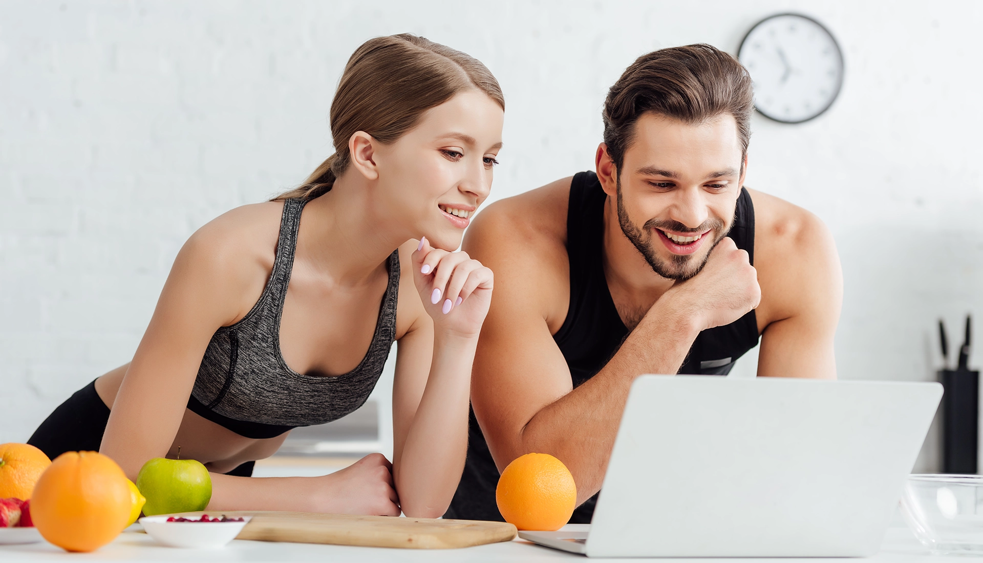 Pareja deportista mirando ordenador.