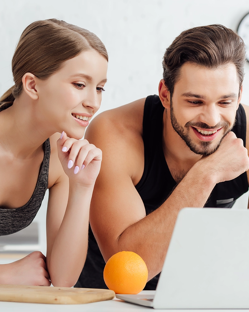 Pareja deportista mirando ordenador.