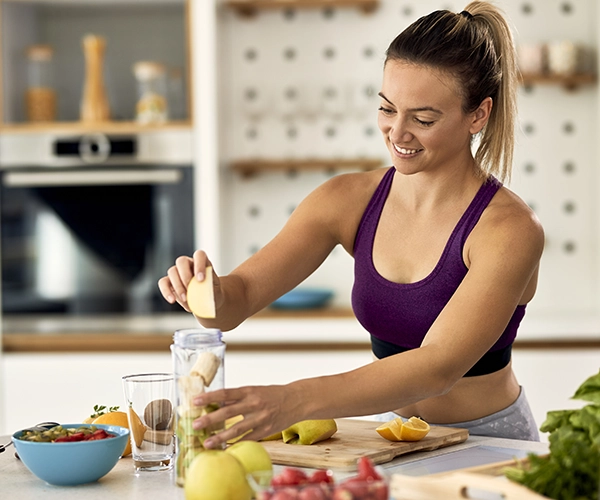 Una chica haciendo un batido.