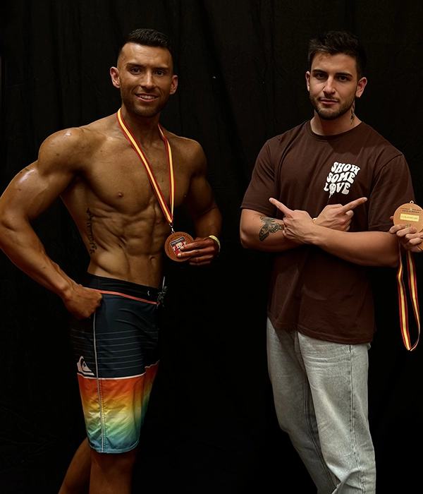 Chico con uno de sus clientes que acaba de ganar una medalla.