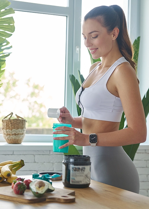 Una chica preparando batido de proteinas.